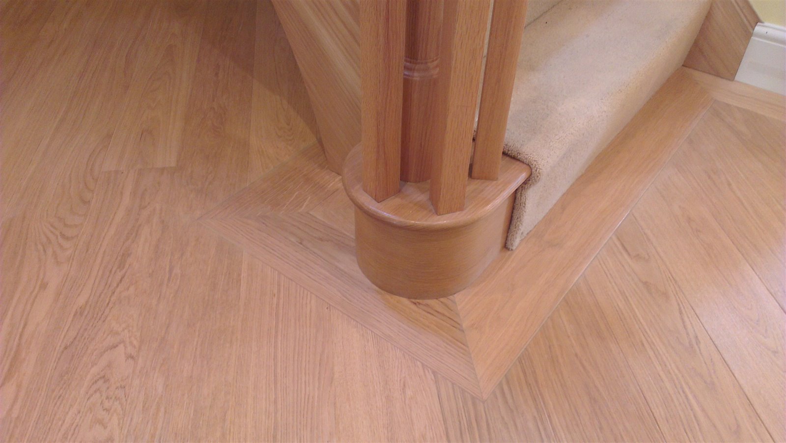 Matching engineered oak border mitred neatly around the rounded bottom bullnose step by Select Line